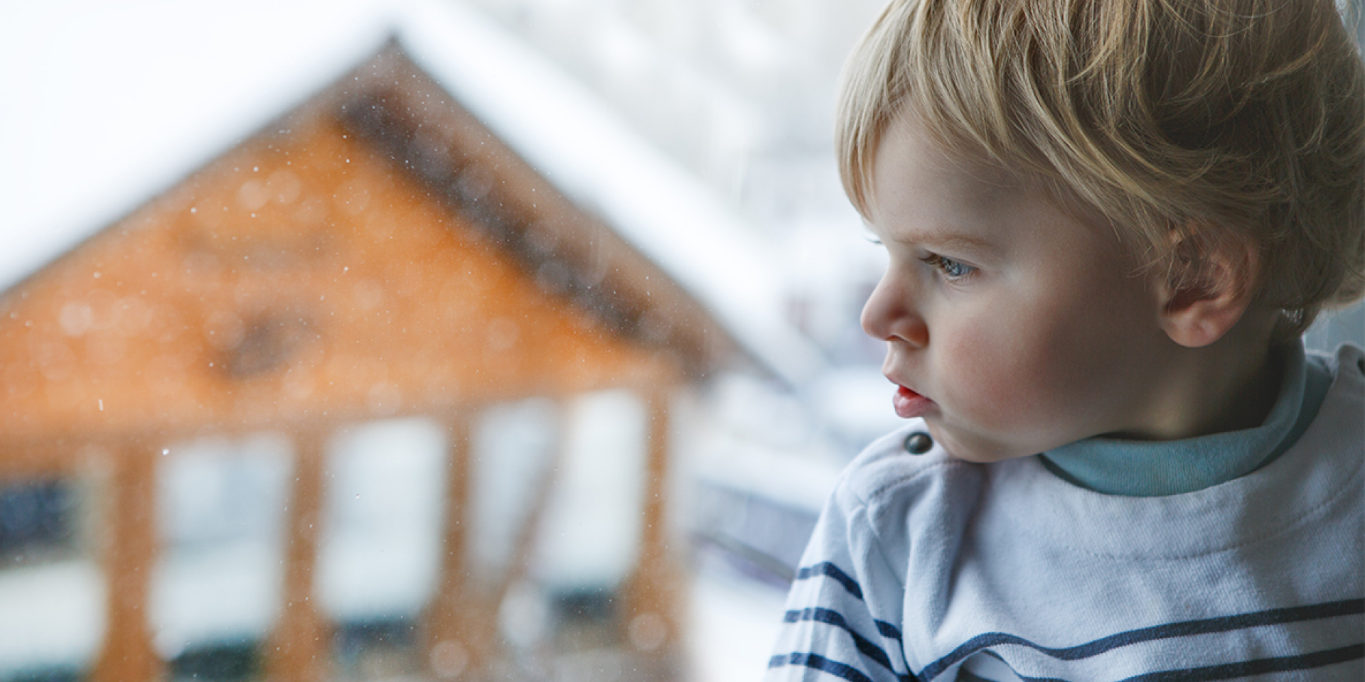 little boy in front of window with snowy scene