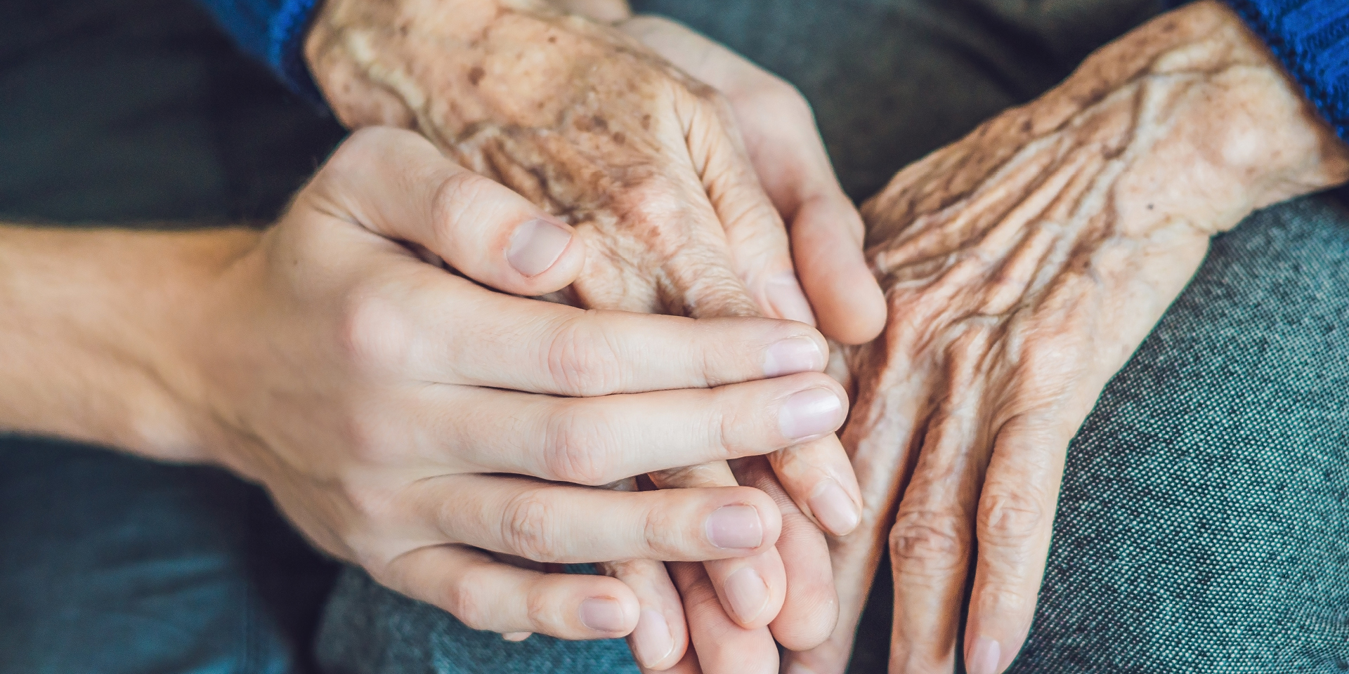 old hands clasped in younger ones