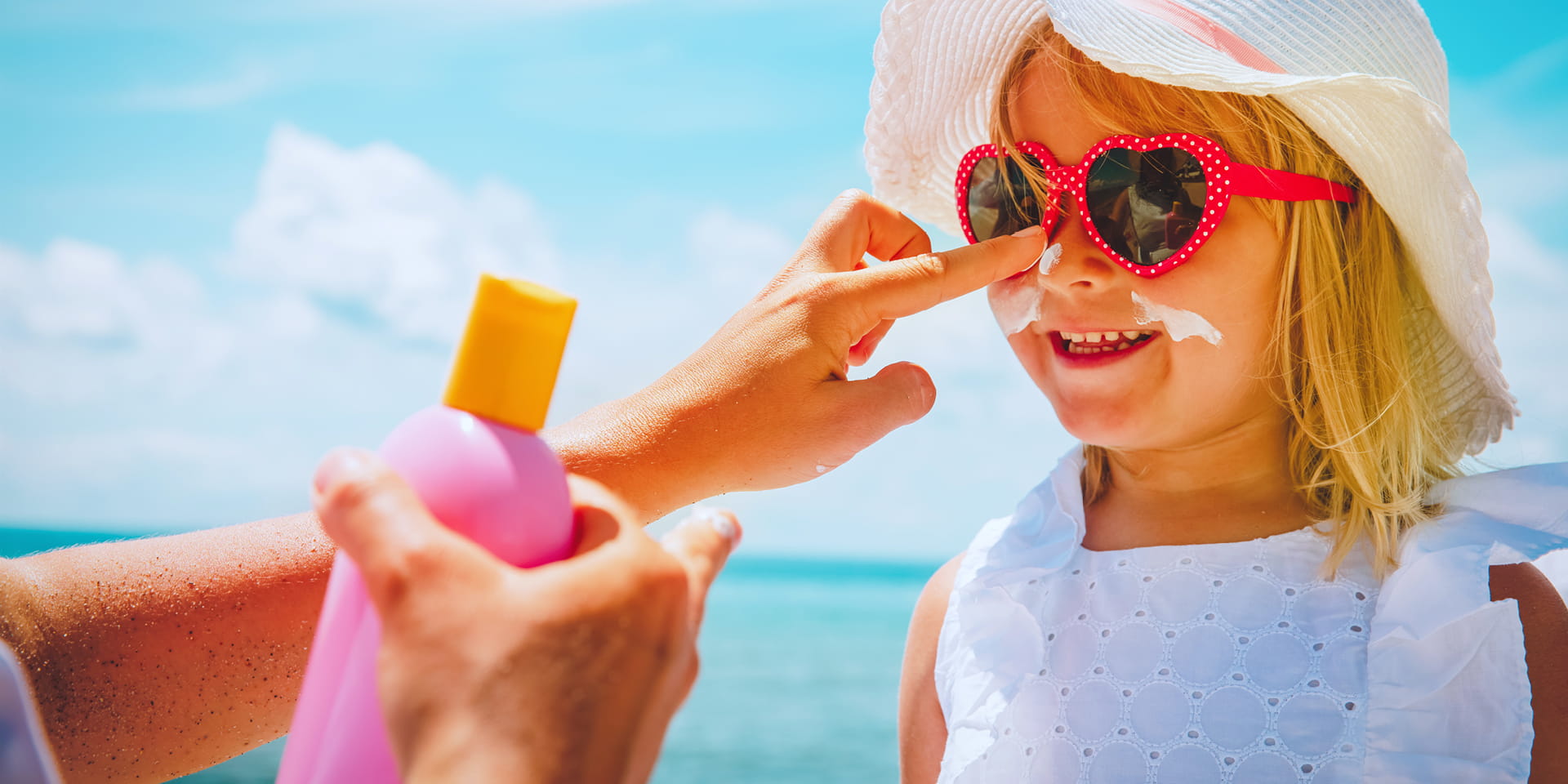 mom putting sunscreen on daughter