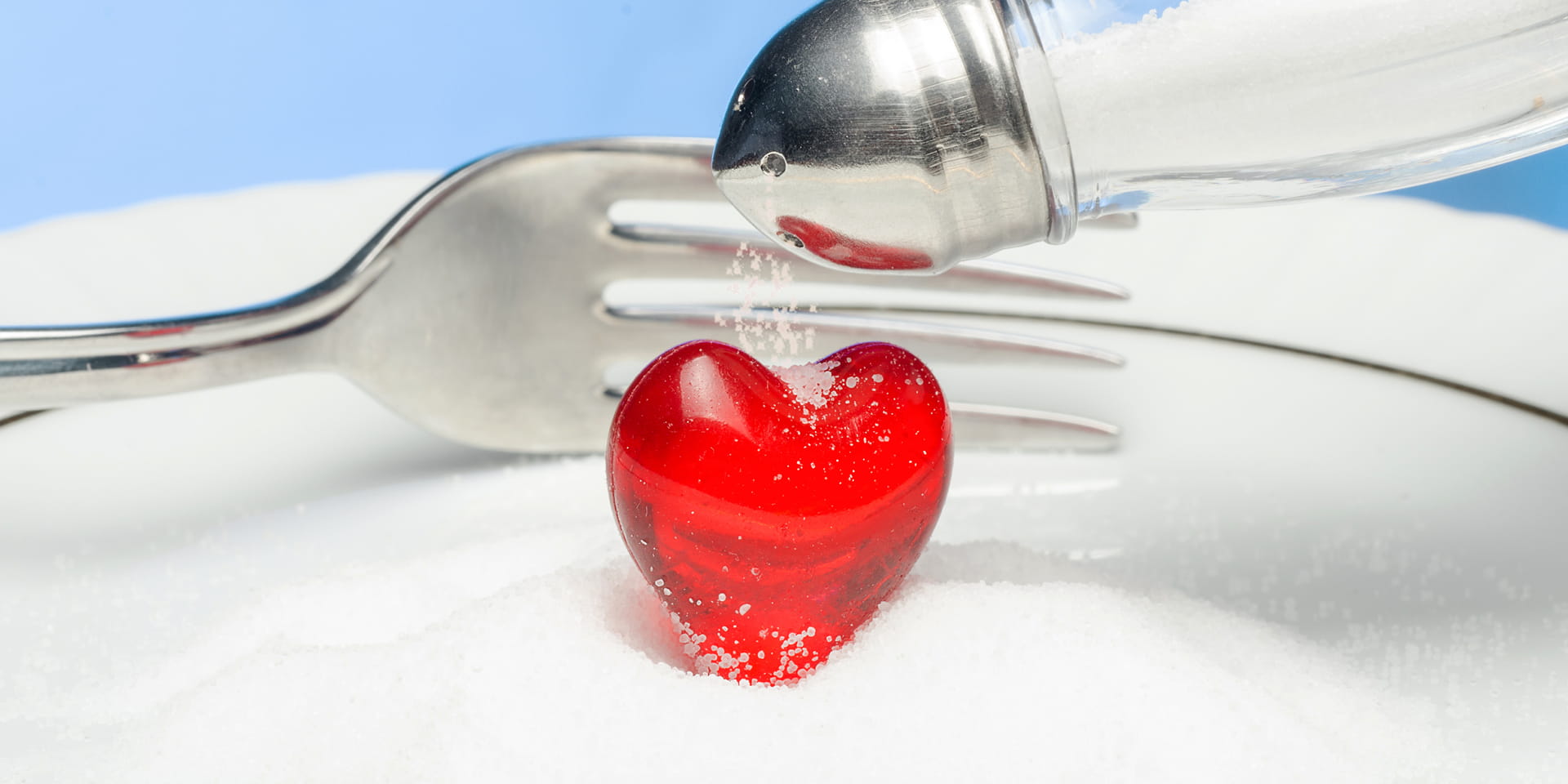 fork cutting into a gummy heart while salt is sprinkled on it