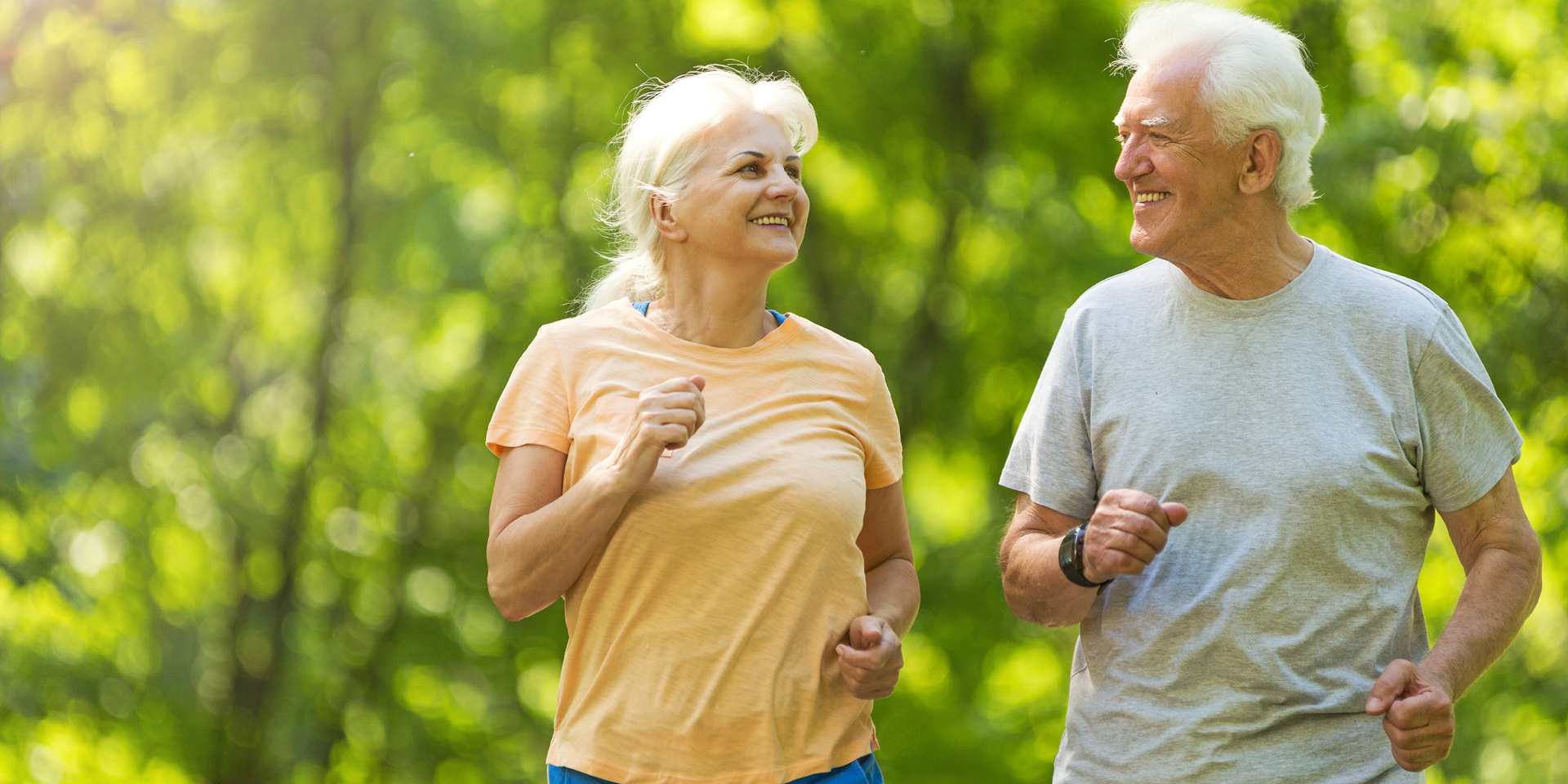 older man and woman jogging in the park