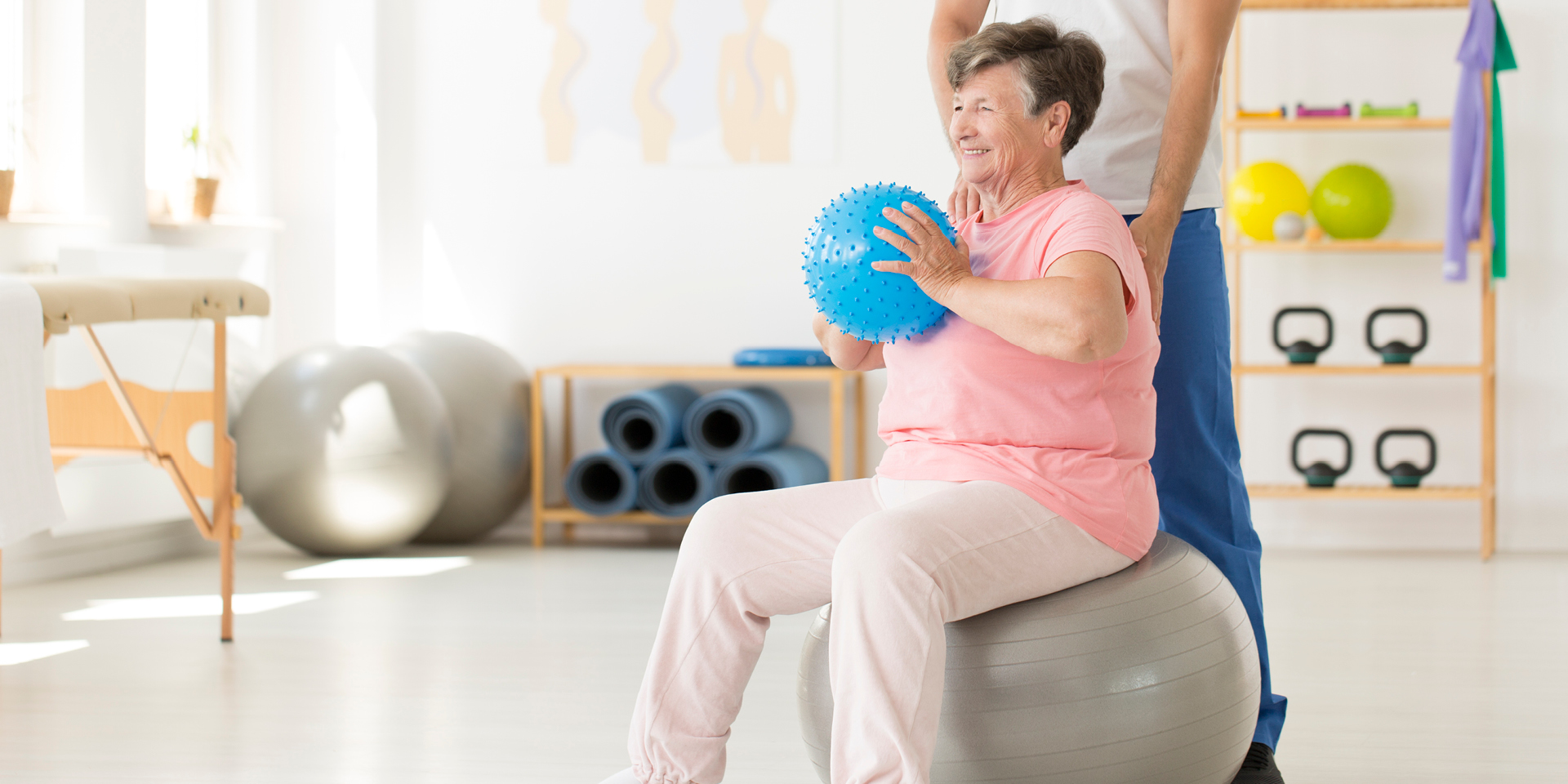 woman sitting on exercise ball with therapist