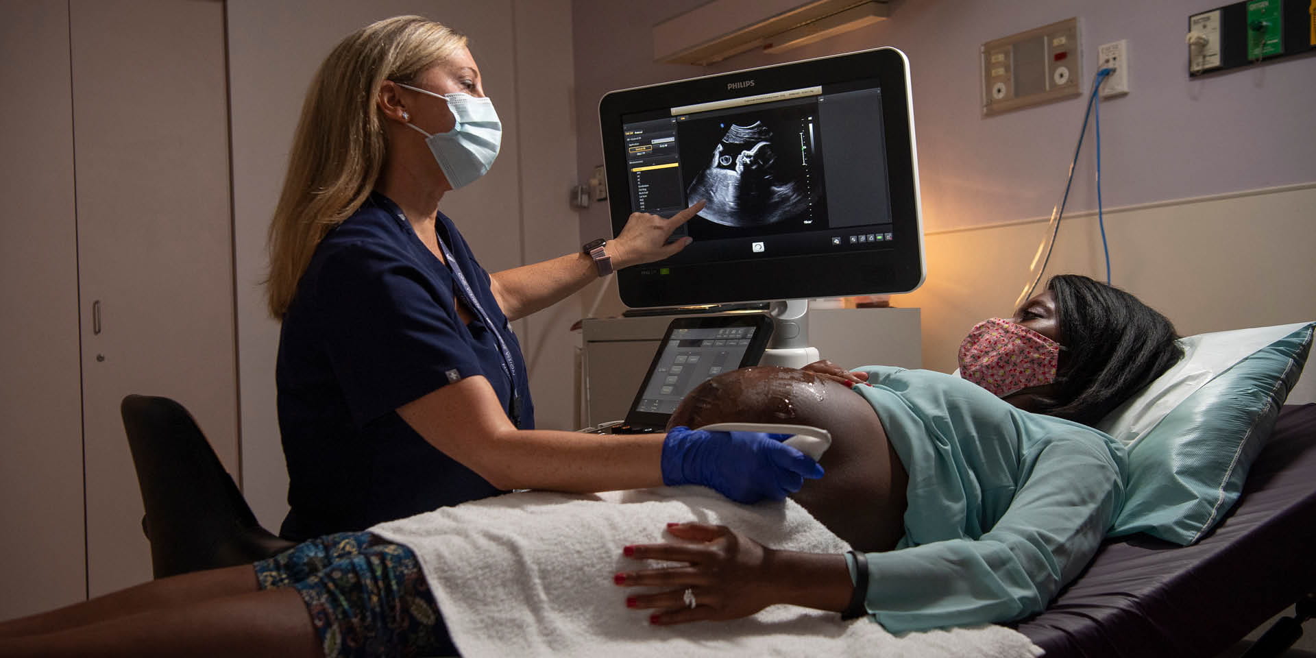 Pregnant patient with nurse operating an ultrasound machine | Doylestown Health