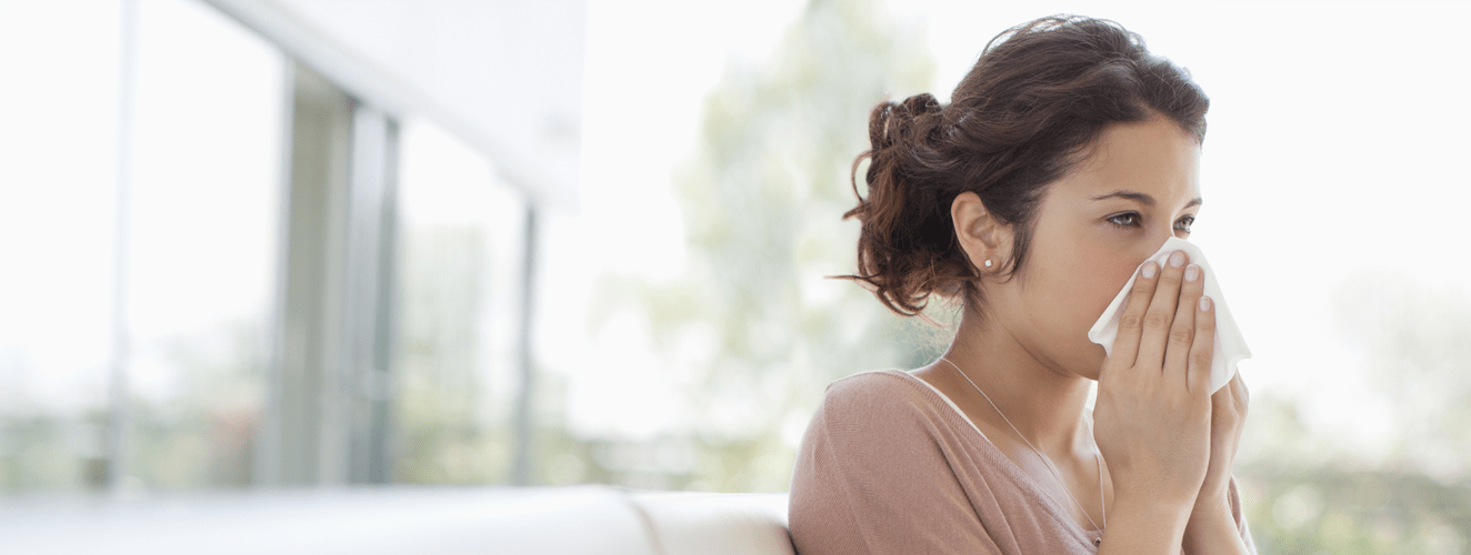 Sick woman blowing her nose | Doylestown Health