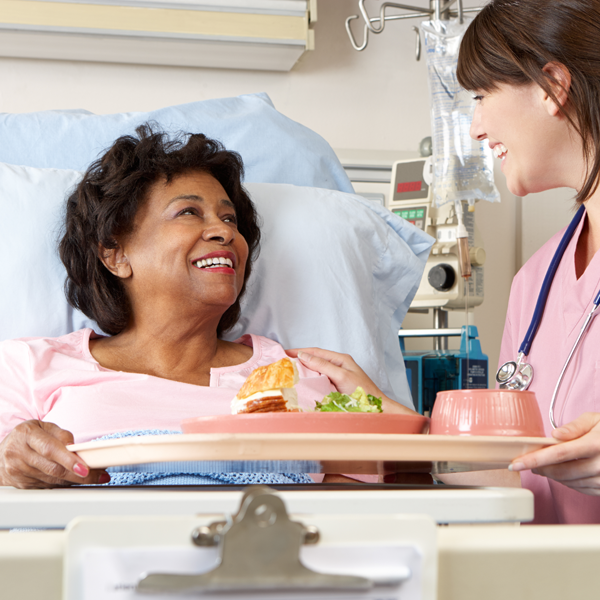 Nurse Serving Senior Patient Meal In Hospital Bed | D0ylestown Health