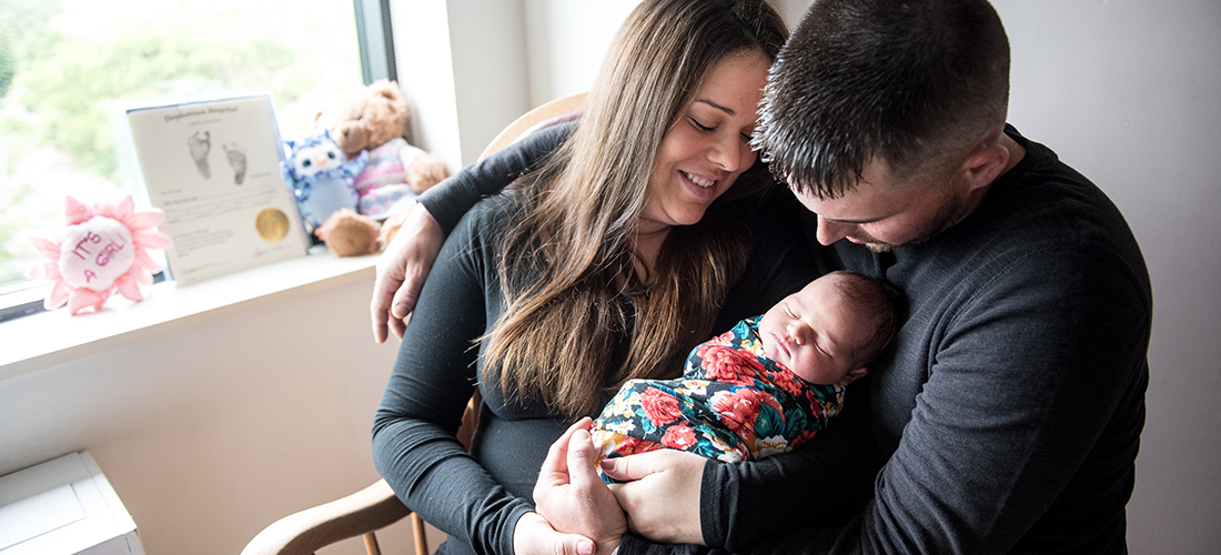Young parents holding their newborn in their arms | Doylestown Health