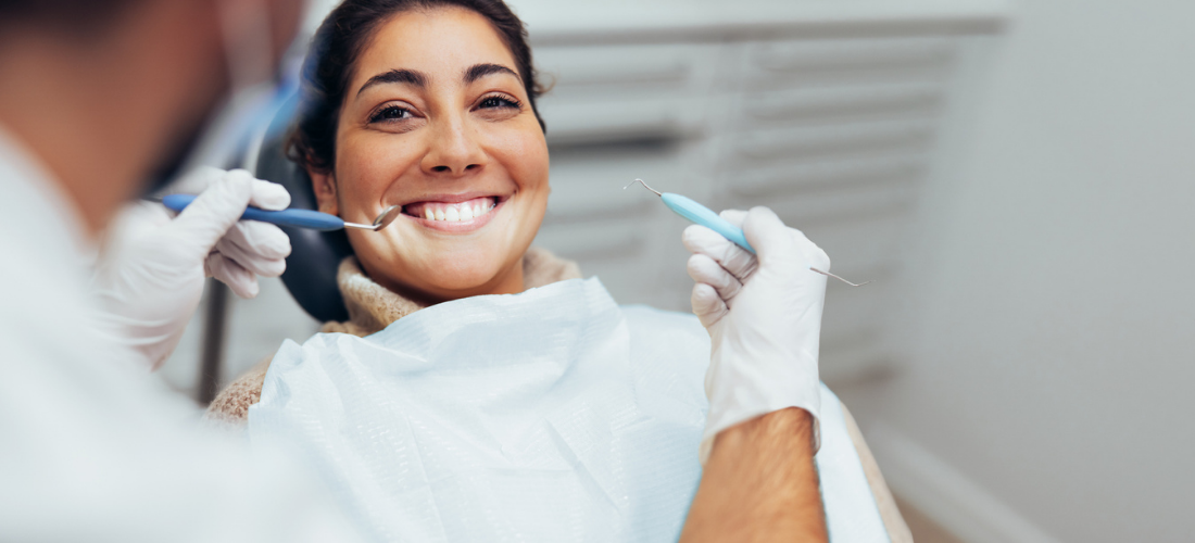 Woman getting dental treatment, patient smiling at a dentist | Doylestown Health